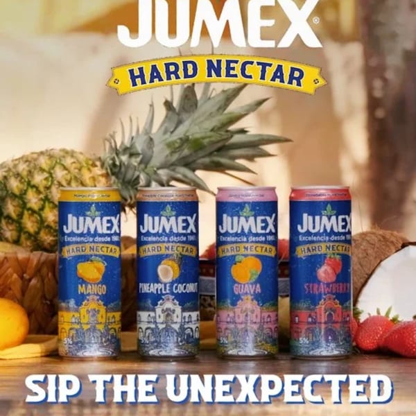 Four Jumex Hard Nectar cans (Mango, Pineapple Coconut, Guava, Strawberry) with fresh fruit.